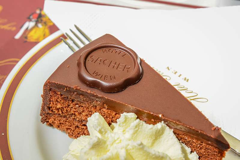 Original Sacher Torte with cream and fork at Sacher Cafe, Vienna, Austria